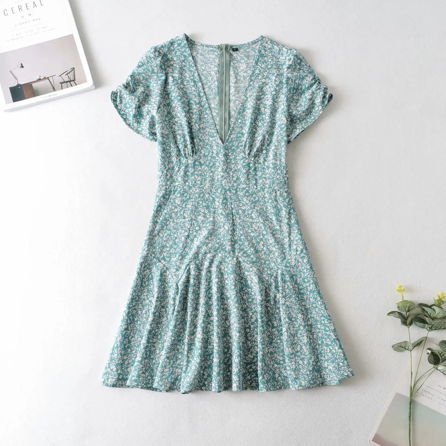 a blue dress sitting on top of a table next to a plant