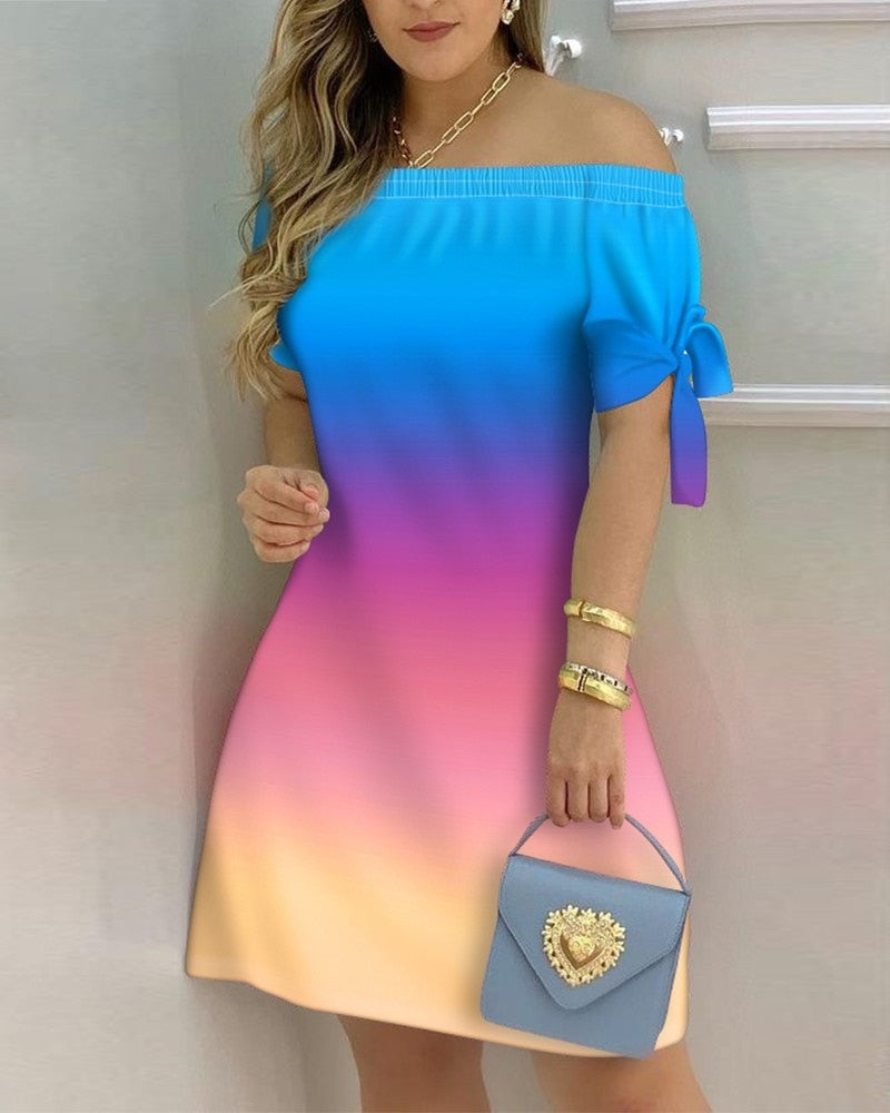 a woman in a blue and pink dress holding a purse