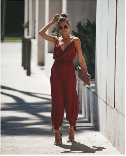 a woman in a red jumpsuit walking down a sidewalk