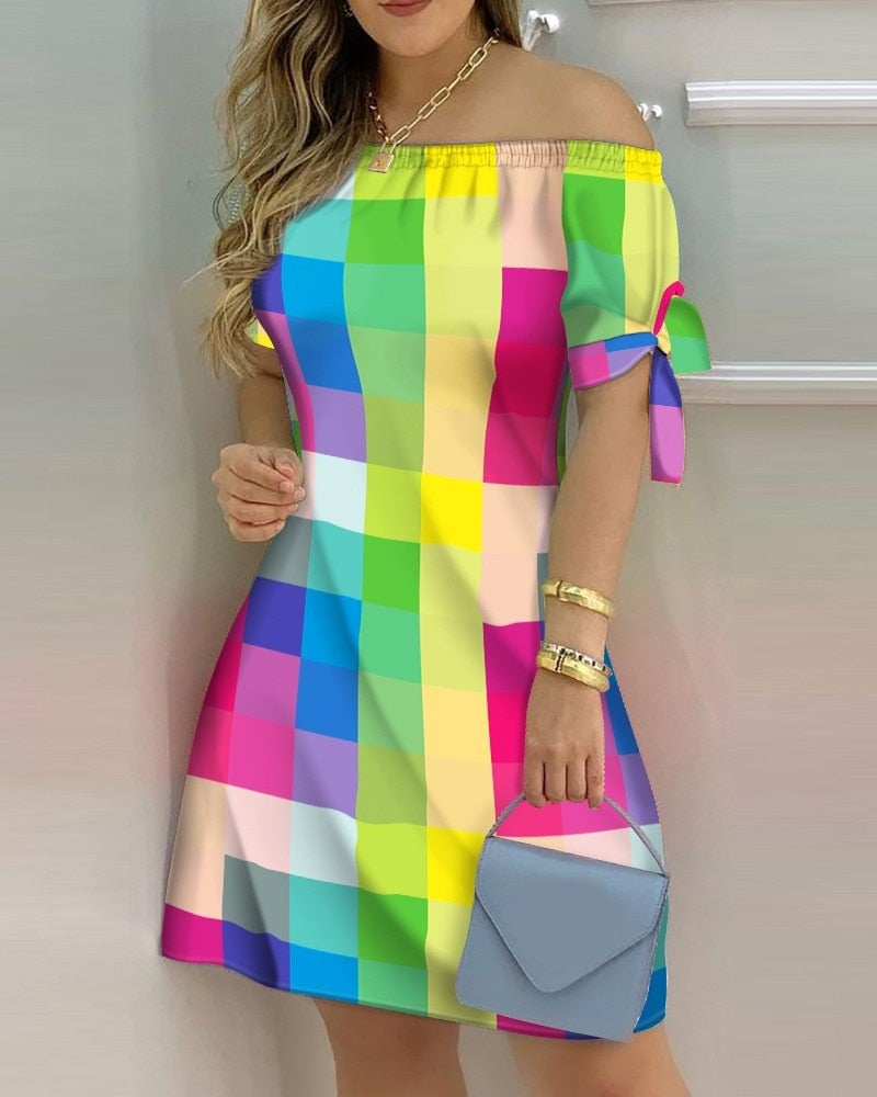 a woman in a colorful dress leaning against a wall