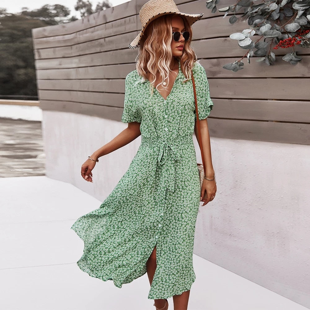 a woman wearing a green dress and a straw hat