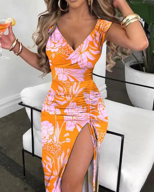 a woman in an orange and pink dress holding a drink