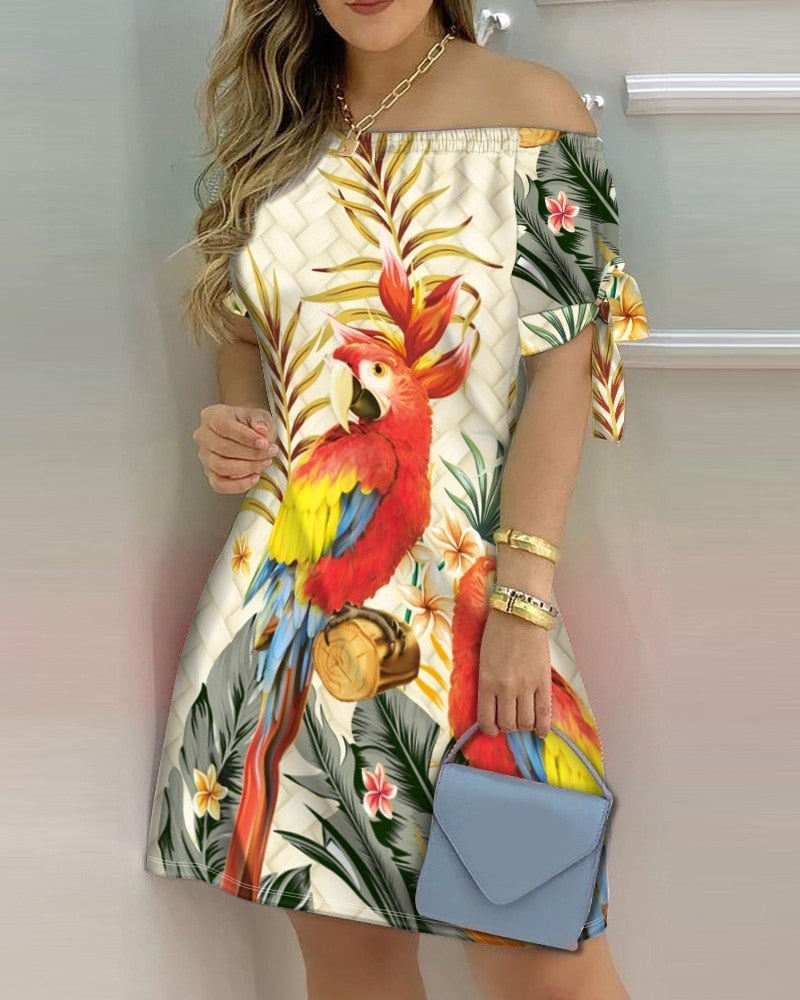 a woman in a tropical print dress holding a blue purse